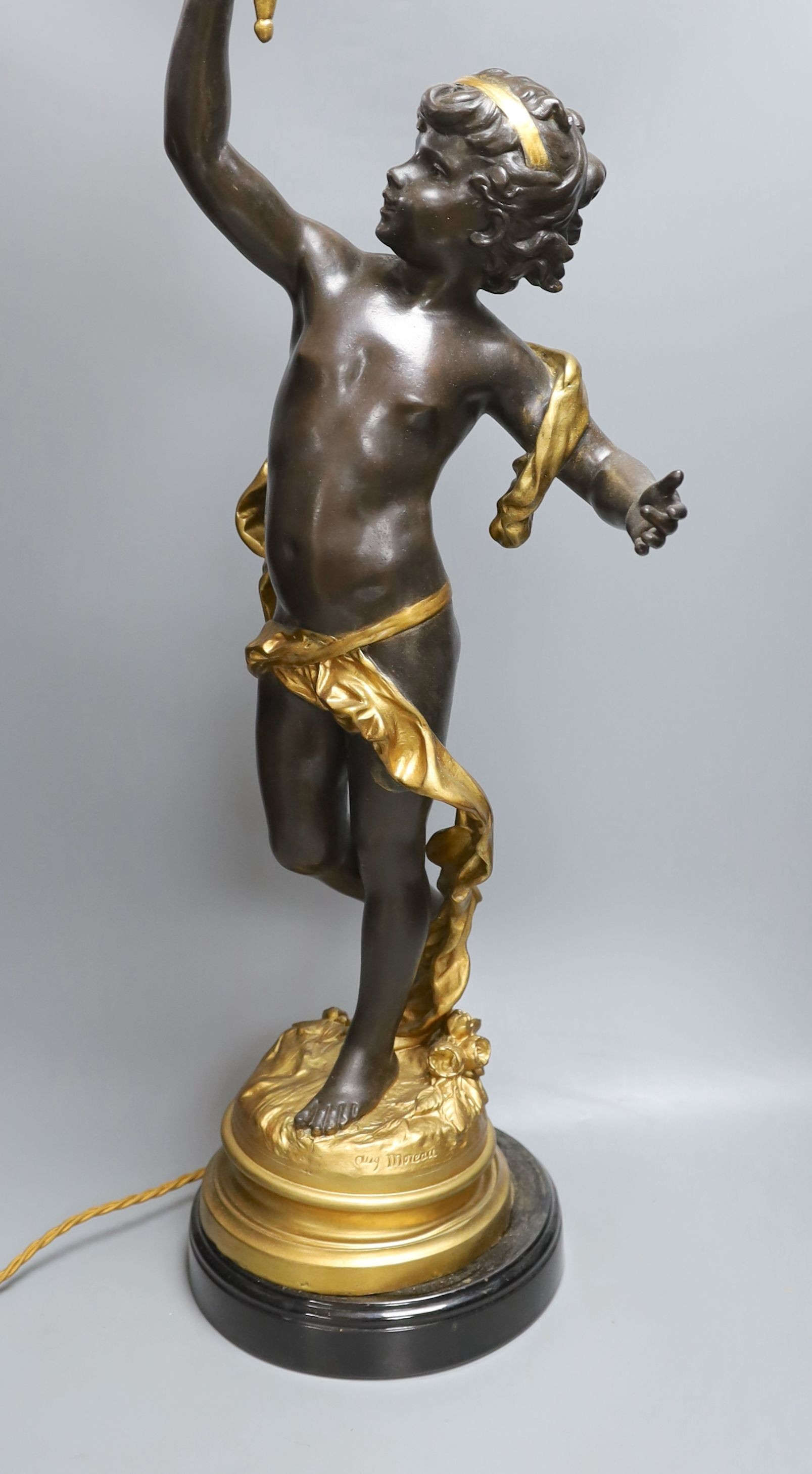 A gilt and brown patinated spelter putto lamp with flame glass shade, signed Moreau